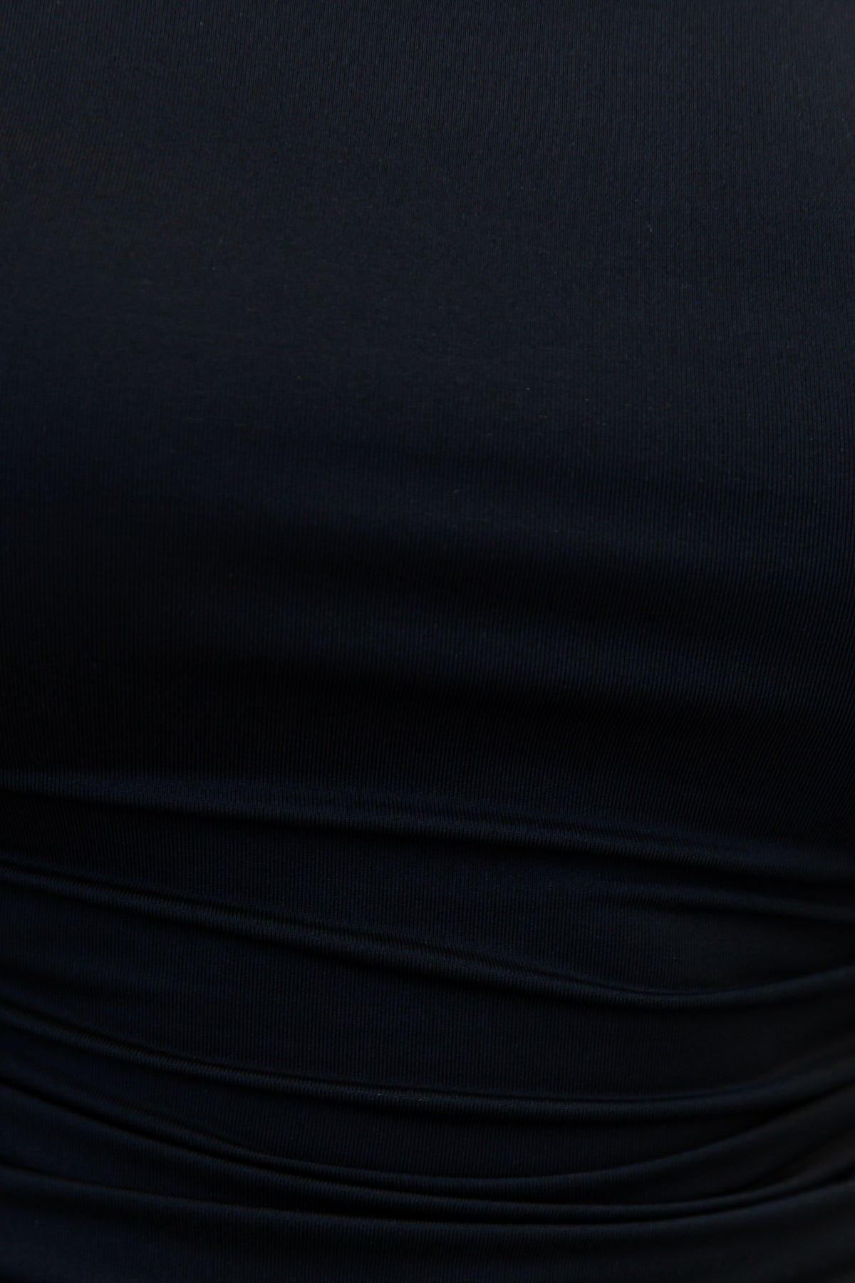 Close-up of Delvey Bodysuit showing off-shoulder style and ruching detail in black fabric.