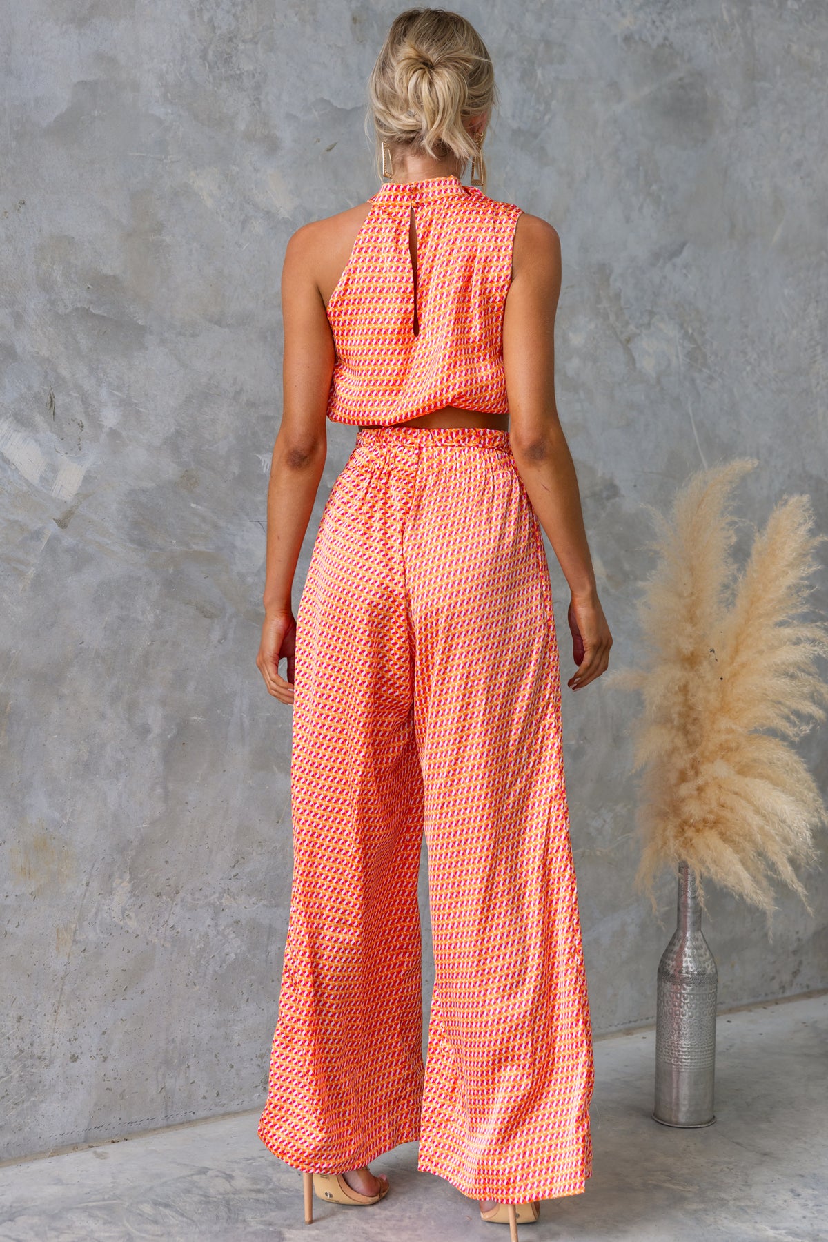 Back view of Dreamie Set featuring a high-neck top and wide-leg pants in a vibrant orange pattern.