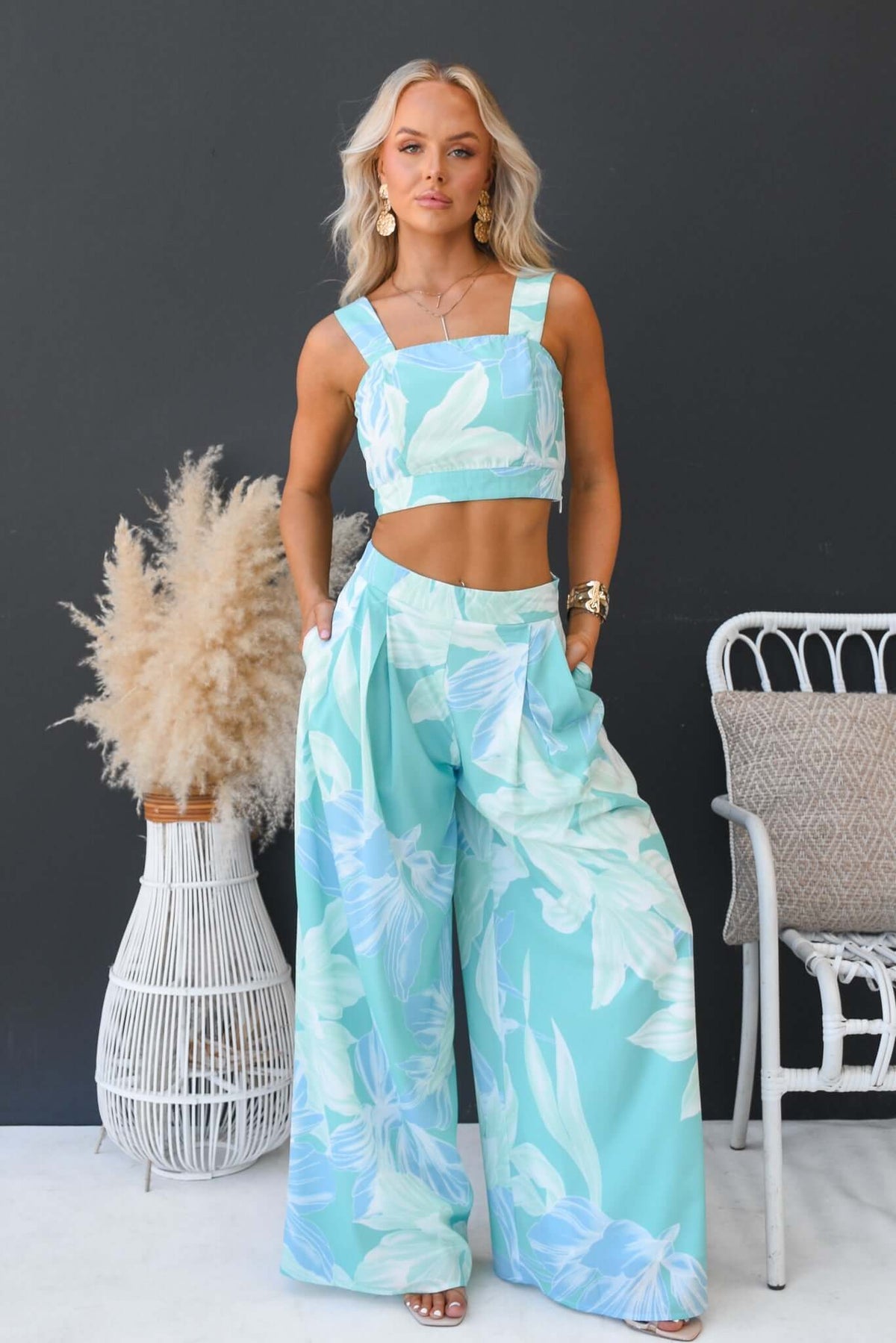 Model wearing New Haven Set with floral print crop top and wide-leg pants in turquoise.