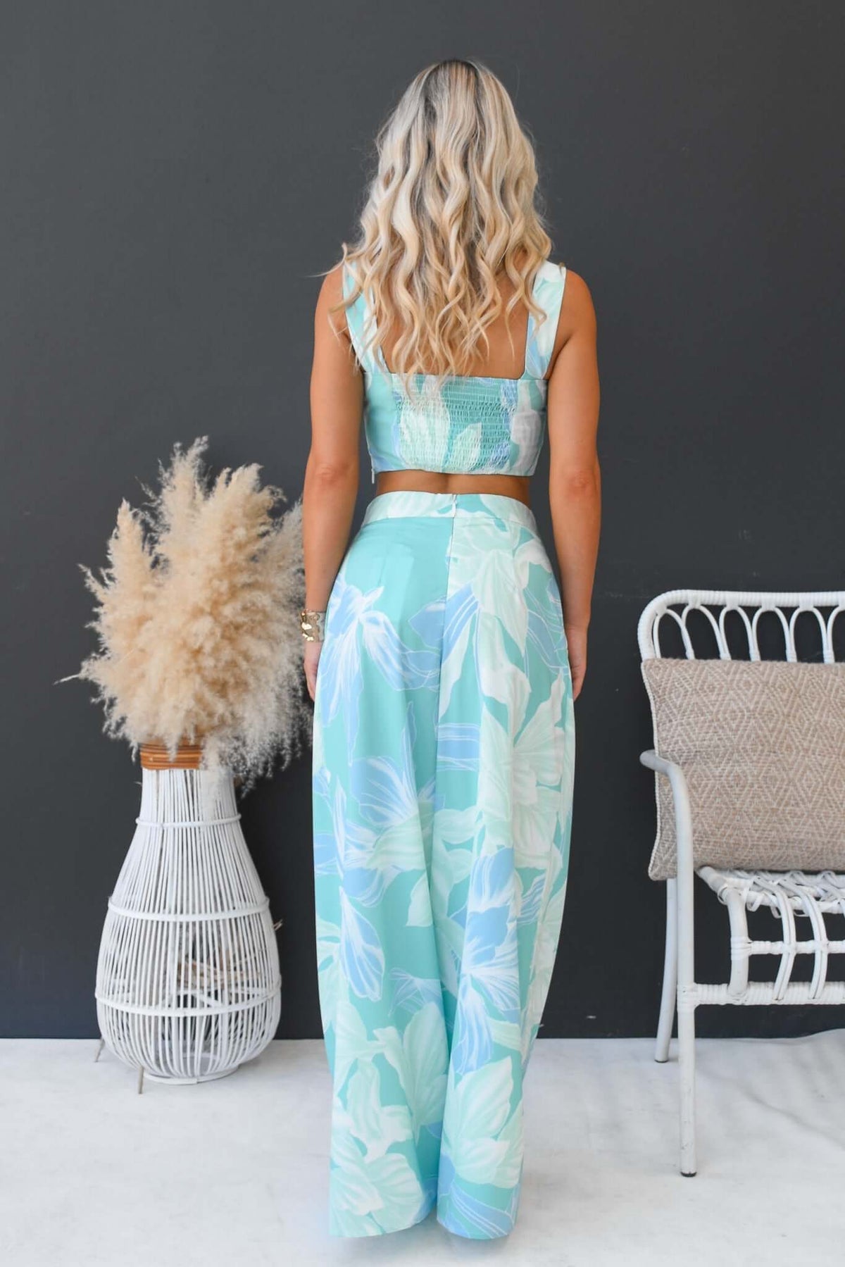 Back view of a woman in a floral New Haven Set featuring a square neckline crop top and mid-high waist pants.