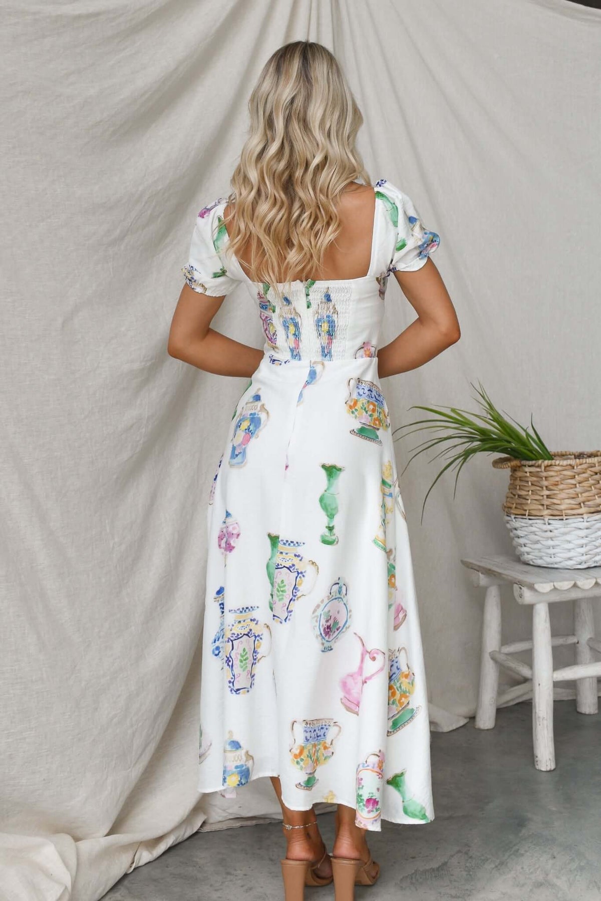 Back view of a Keyser Midi Dress featuring colorful vintage print with short sleeves and a flowing silhouette.