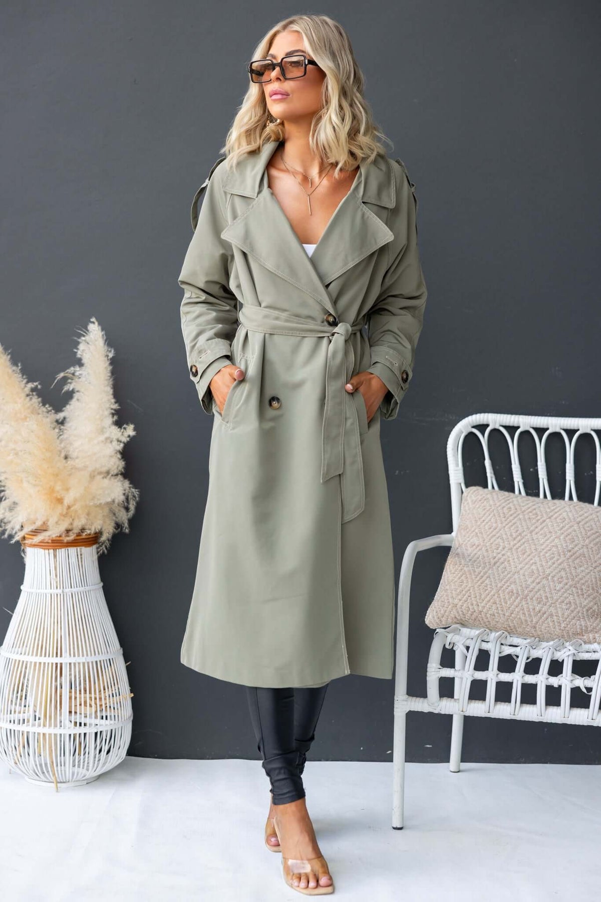 Fashionable oversized Eino coat in olive green with a removable belt, front buttons, and pockets. Perfect for stylish layering.