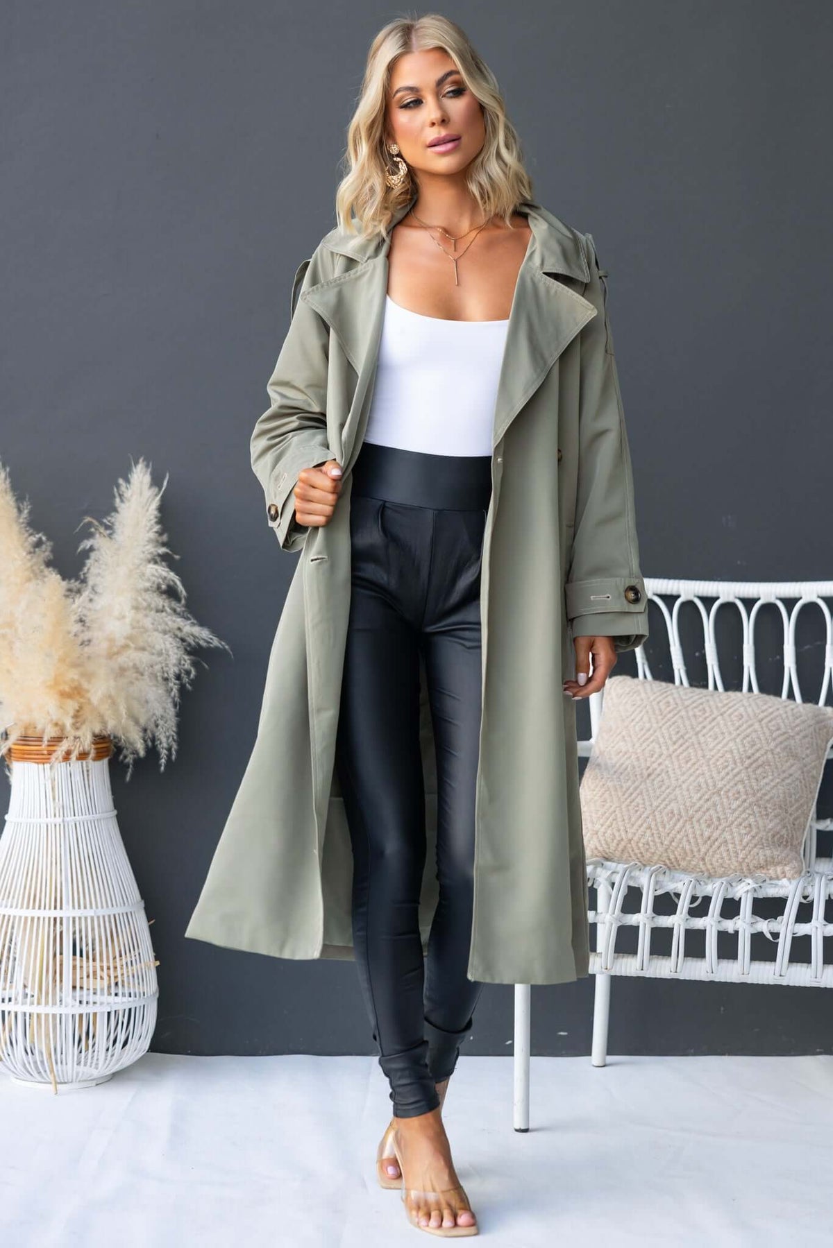 Eino Coat in olive green trench style, featuring collar, button closure, removable belt, and oversized fit.