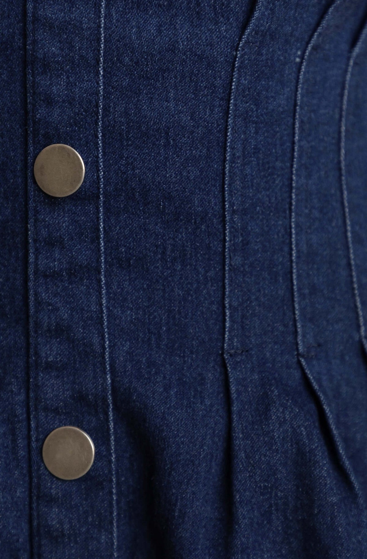 Close-up of Elidi Denim Dress fabric with button detail and texture.