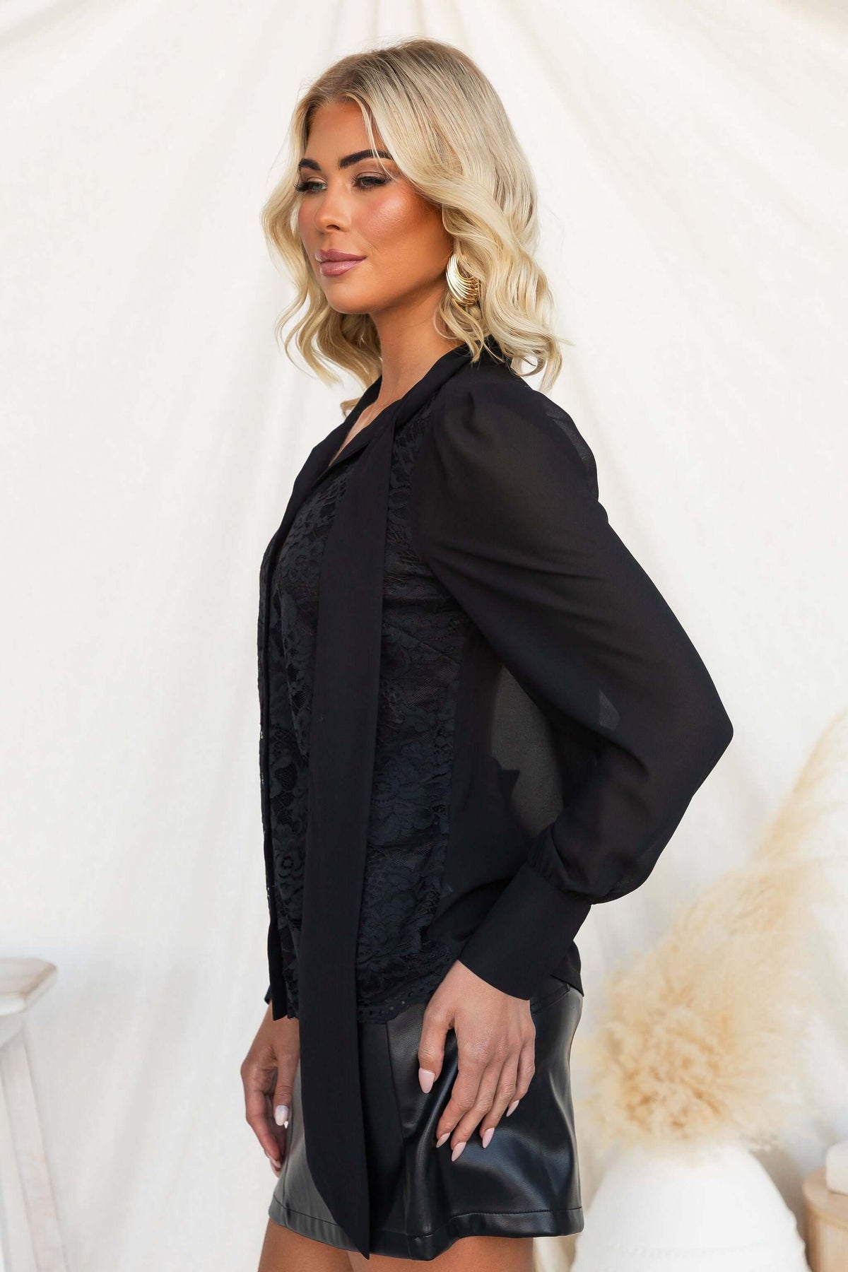 Model wearing Elijah Shirt featuring lace detail and tie neckline in black chiffon.