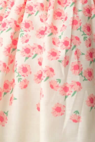 Floral print fabric with pink flowers and green leaves on a white background, ideal for a feminine dress design.