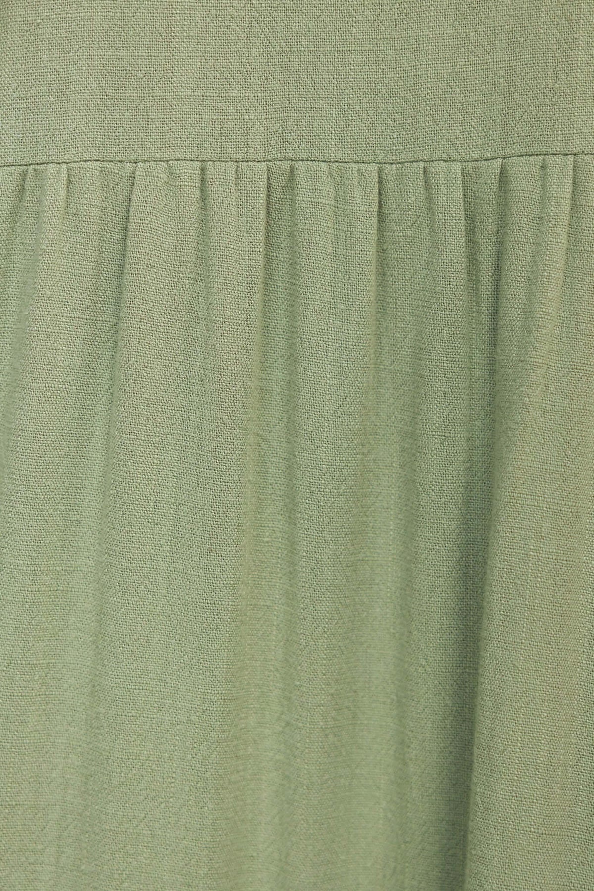 Close-up of the soft green fabric of the Erikson Maxi Dress, showcasing its flowy design and texture.