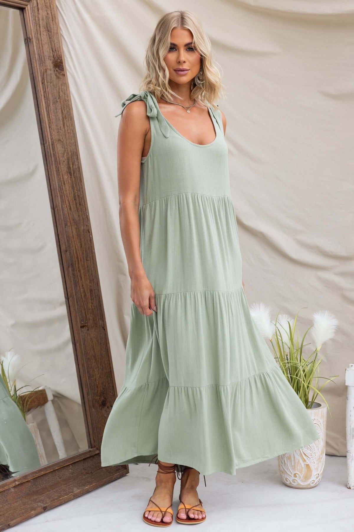 Model wearing an Erikson Maxi Dress in green, featuring tie straps and a relaxed fit, set against a stylish mirror backdrop.