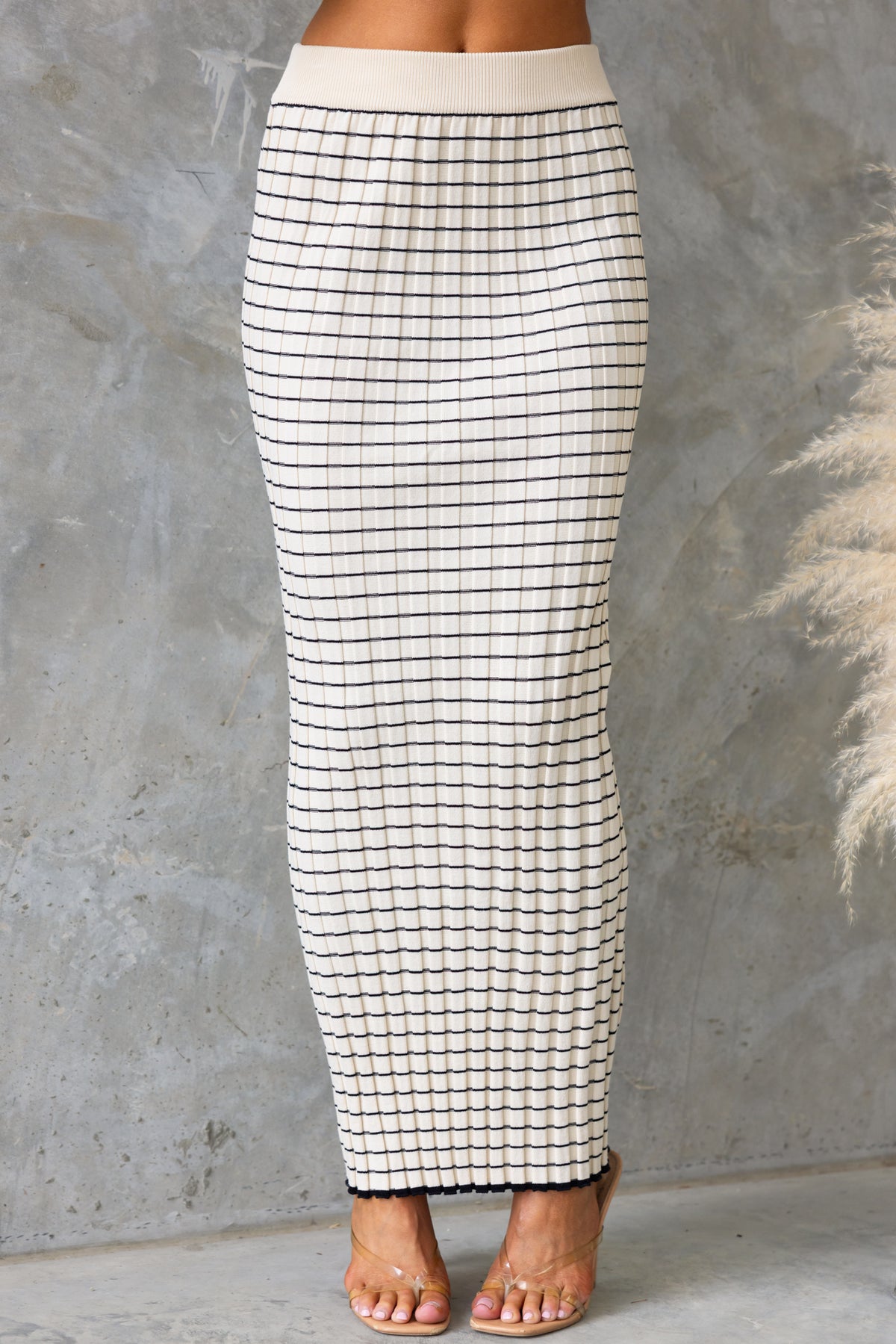 Escala Maxi Skirt with mid-high waist fit, elastic waistband, and stretch knit material in a grid pattern.