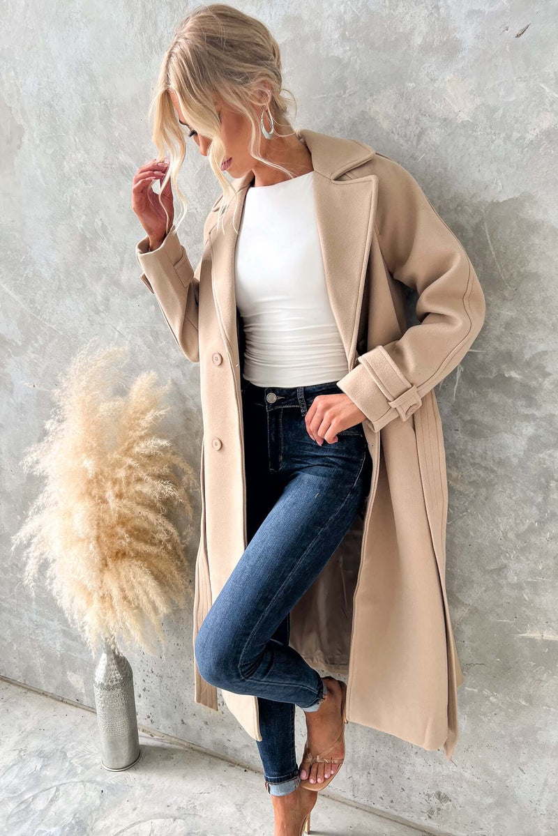Woman wearing a longline Farina coat with collar, button-up front, and jeans, showcasing a stylish look.