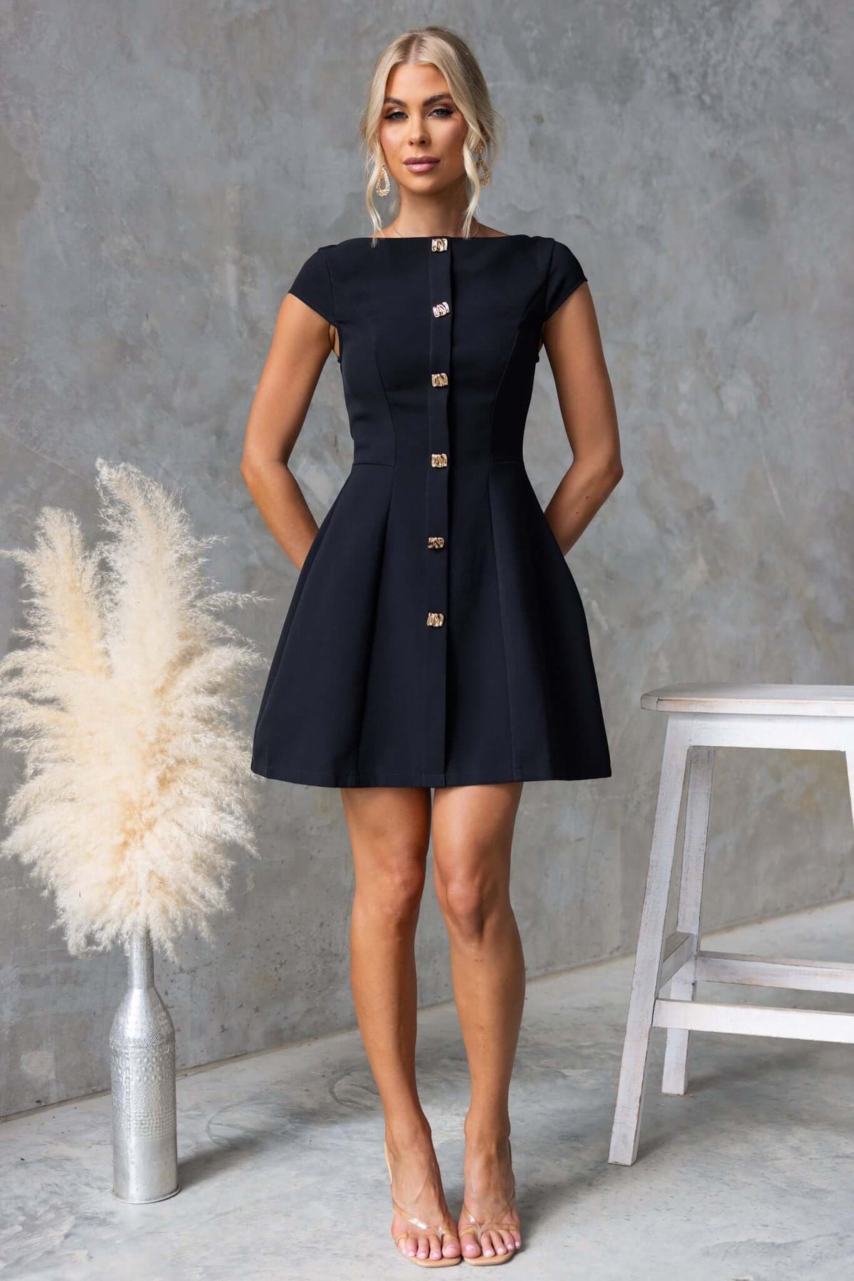 Model wearing Feist Dress featuring a boat neckline and faux buttons, styled with a minimalist backdrop.