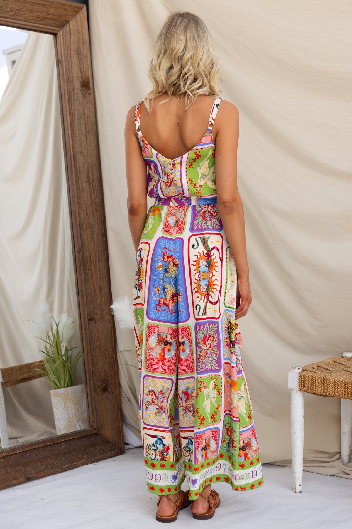 Model wearing Fidenz Jumpsuit with adjustable straps and colorful print, showcasing back view.
