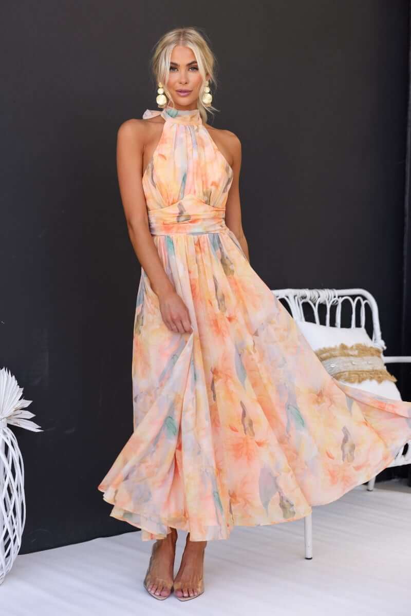 Floral print Little Things Maxi Dress with high tie neckline, model wearing size XS, showcasing a soft pastel color palette.