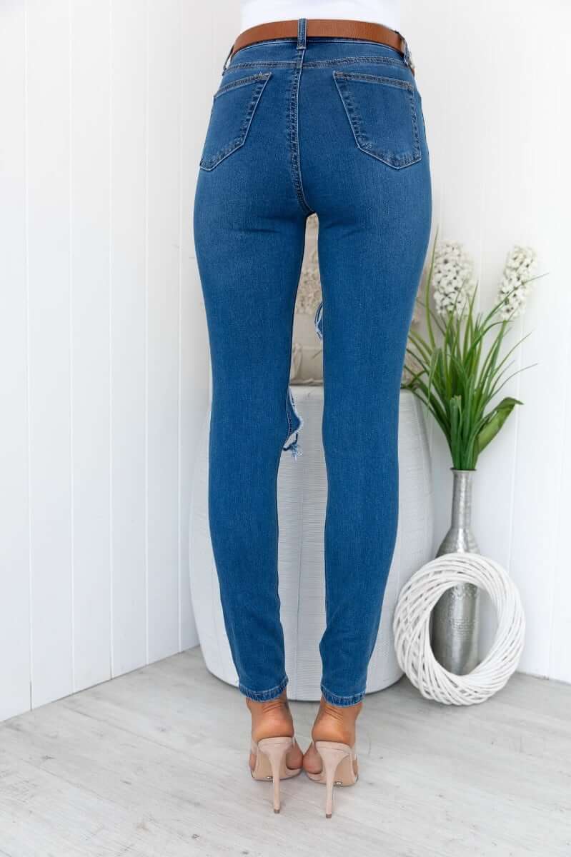 Back view of Glory Jeans featuring distressed rip details, skinny fit, and stylish design, showcasing a standard fit with stretch.
