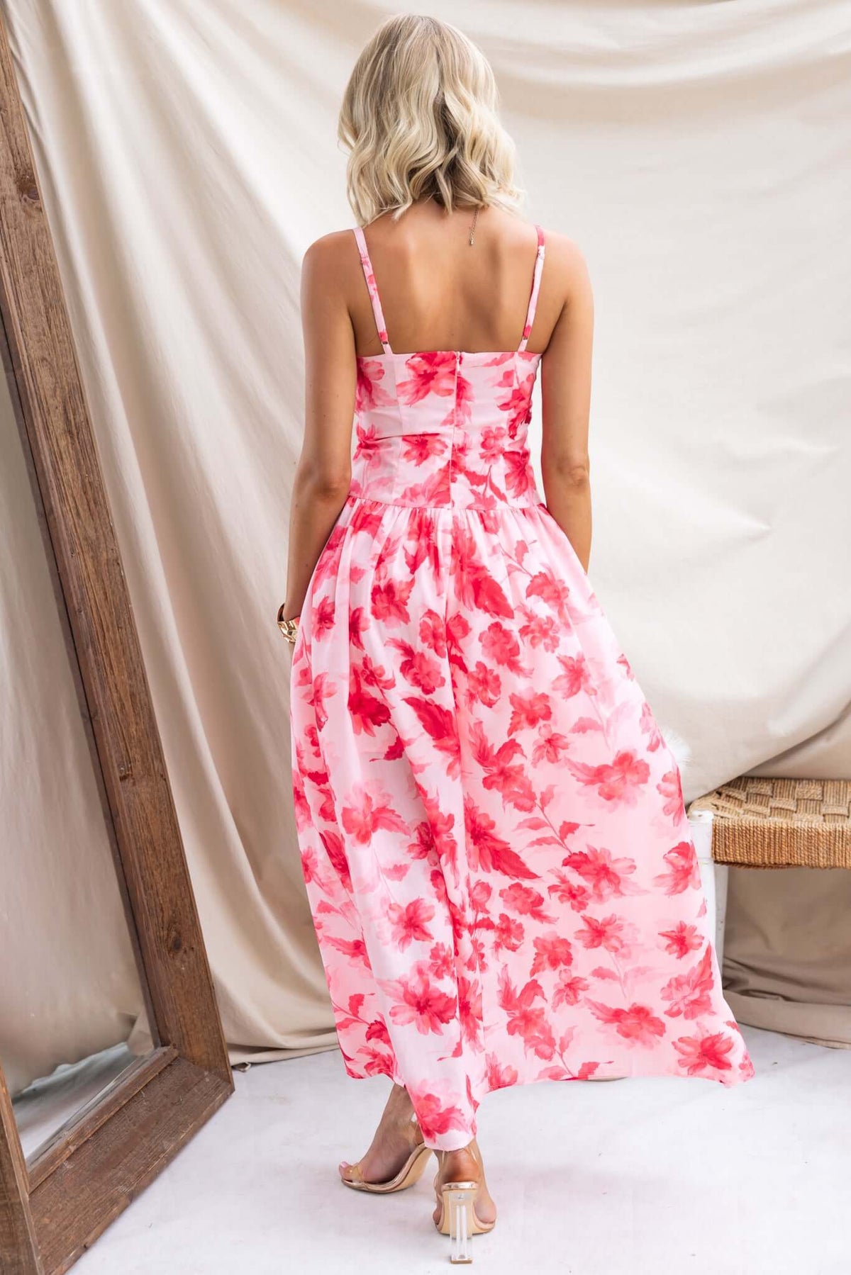 Back view of Hazelle Maxi Dress with adjustable straps and floral pattern, featuring split front and gold hardware detail.