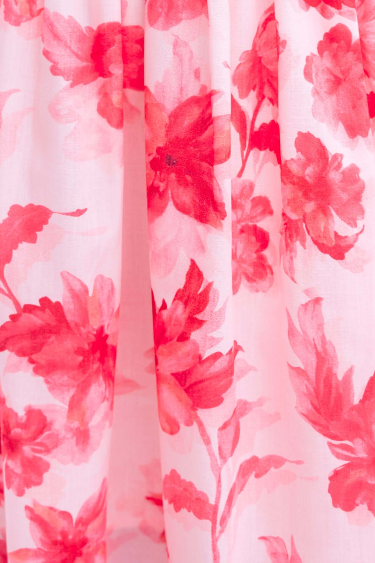 Close-up of pink floral pattern on fabric of Hazelle Maxi Dress, featuring soft red flowers on a light background.