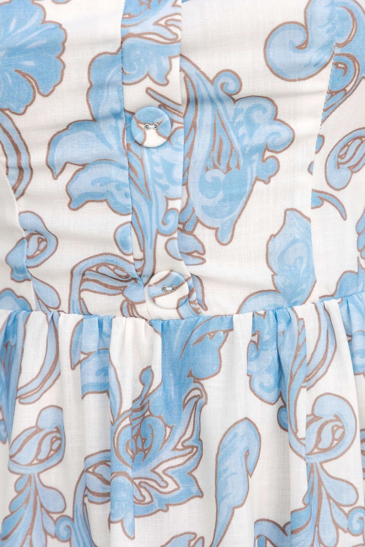 Close-up of the fabric detail of Heritage Bloom Maxi Dress featuring faux buttons and floral design in blue.