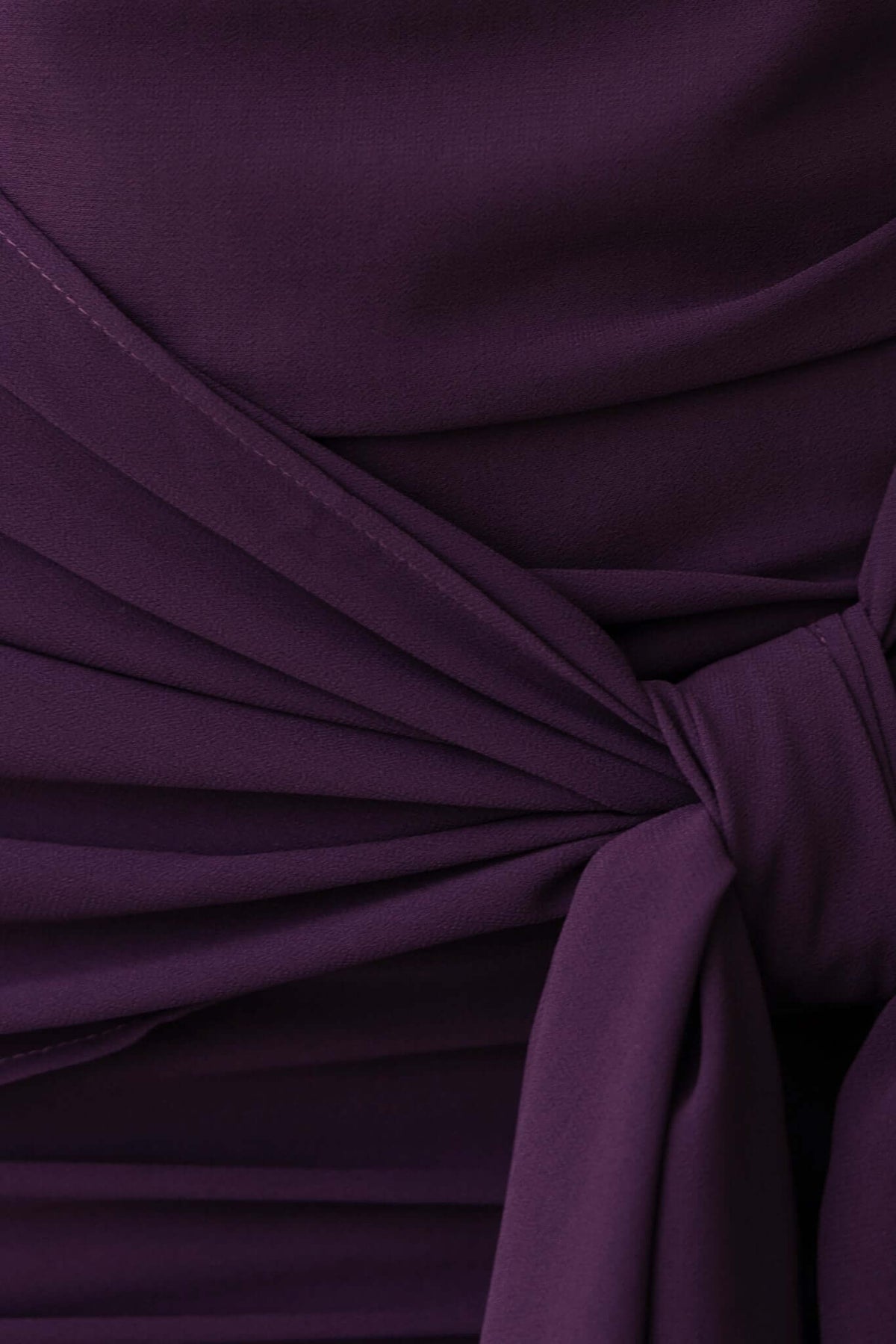 Close-up of the purple fabric and tie detail of the Iconic Maxi Dress, featuring pleats and smooth texture.