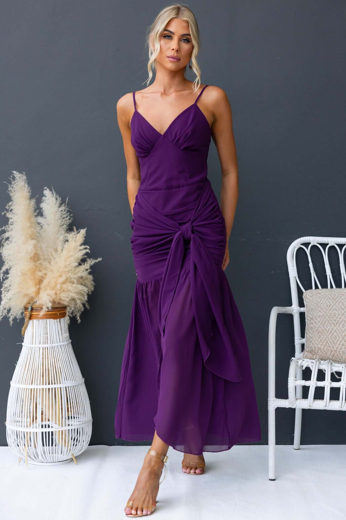 Model wearing a purple iconic maxi dress with adjustable straps and front split, showcasing elegant design and fit.