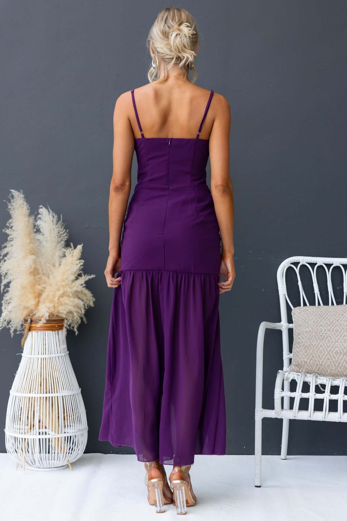 Back view of a stylish iconic maxi dress with adjustable straps and a flowy skirt in rich purple color.