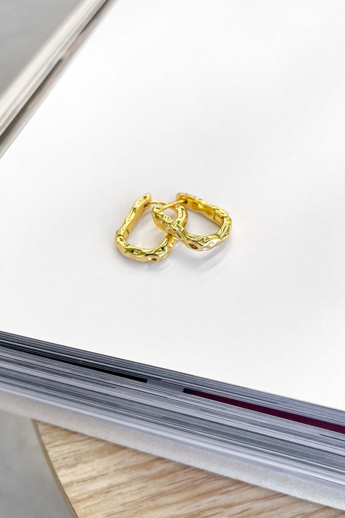 Gold Laila Earrings displayed on a clean white surface, showcasing their elegant design and clasp closure.