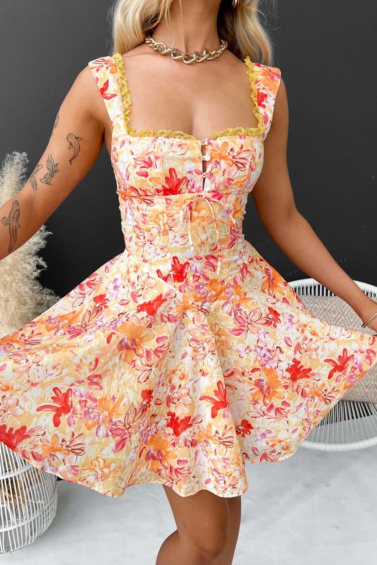 Elixir Dress featuring floral pattern, adjustable straps, tie detail, and tulle underlay, perfect for summer wear.