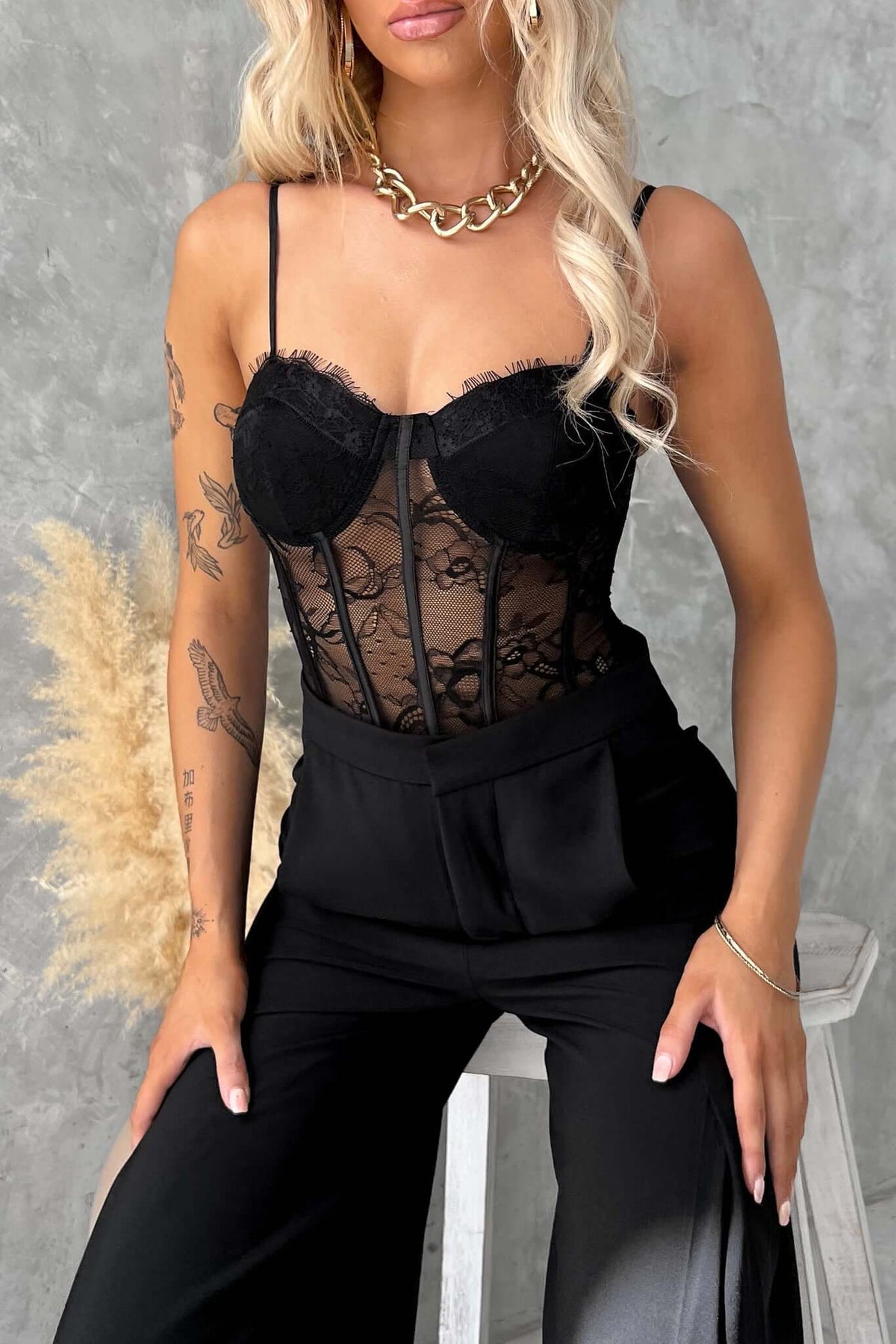 Model wearing Davies Bodysuit with adjustable straps, lace detailing, and a black outfit, showcasing stylish comfort.