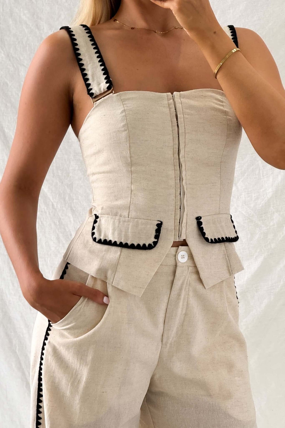 Fallon Set featuring a fitted top with adjustable straps and faux pockets, paired with mid-high waist pants.