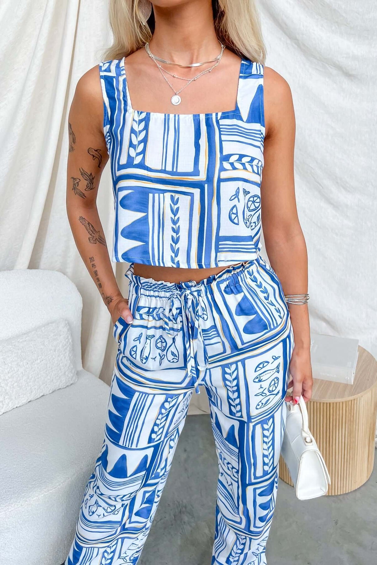 Model wearing Minxie Top with square neckline, paired with matching patterned pants in blue and white.