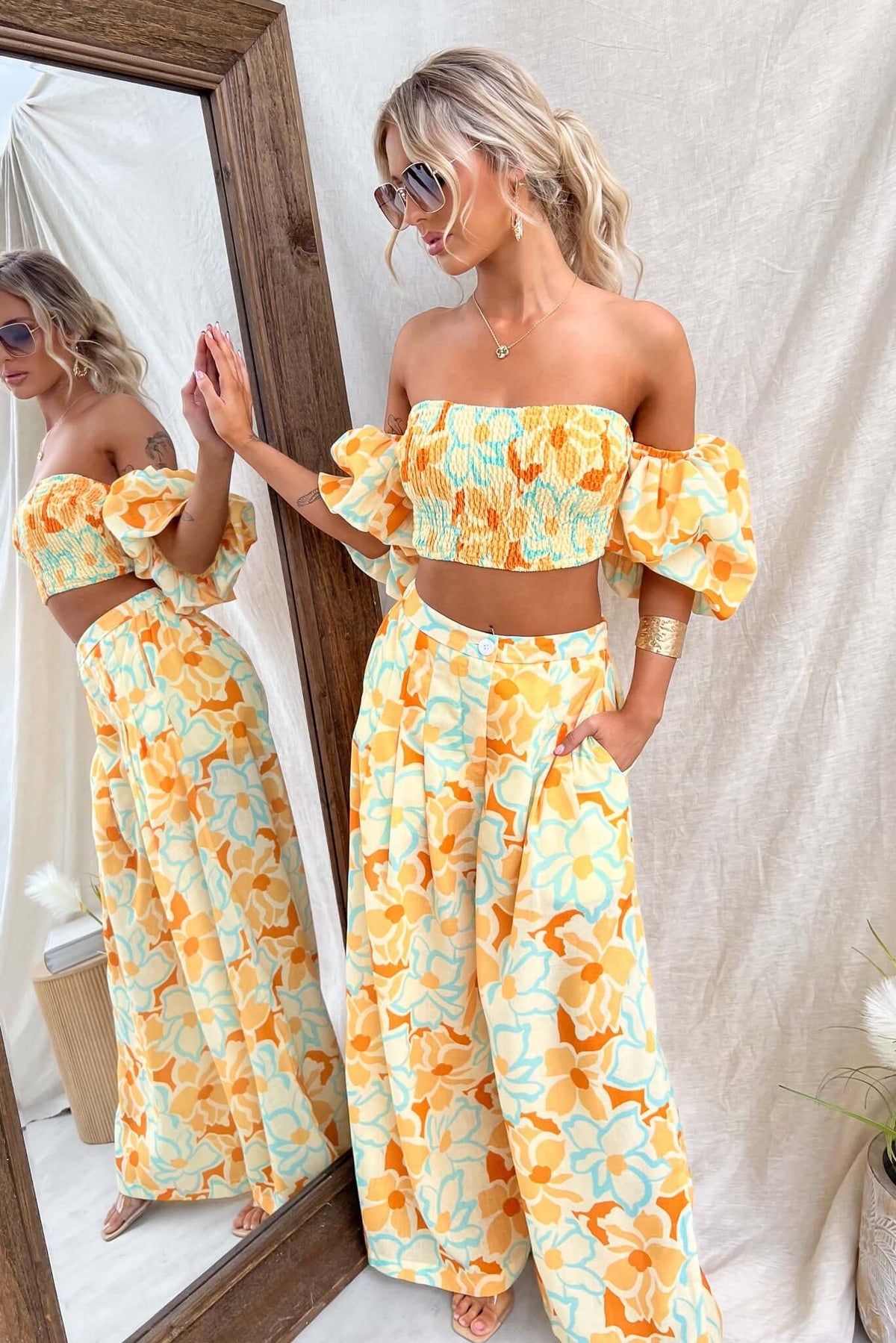 Olessia Set featuring a model in a floral crop top with puff sleeves and wide-leg pants, styled with sunglasses.