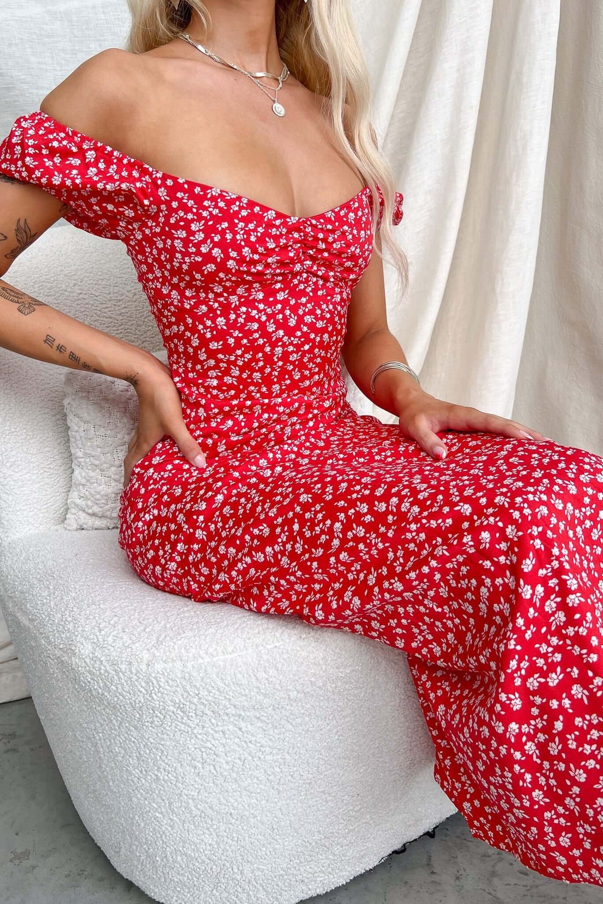 Model wearing Frankle Maxi Dress in red floral print, showcasing off-shoulder design and fitted silhouette.