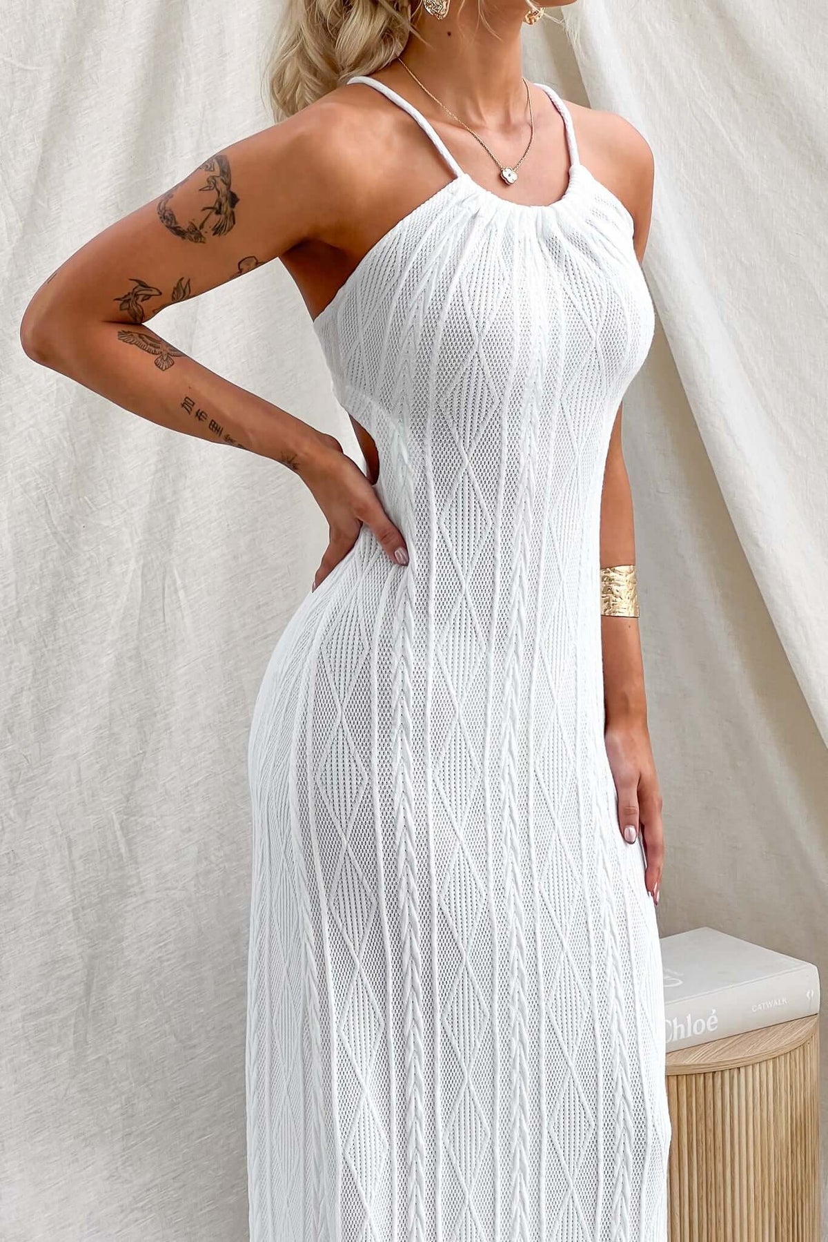 Elegant model in a white Dream Weaver Maxi Dress with a tie neckline and fitted design, showcasing its beautiful knit material.