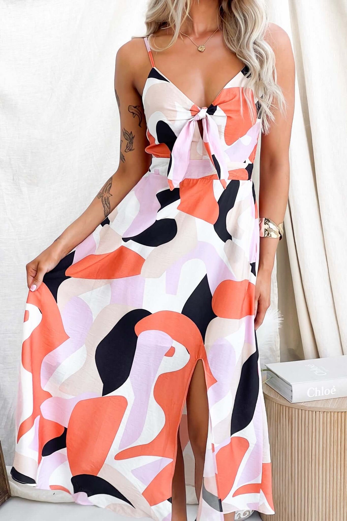 Modina Midi Dress featuring adjustable straps, tie at bust, split front, and vibrant abstract pattern.