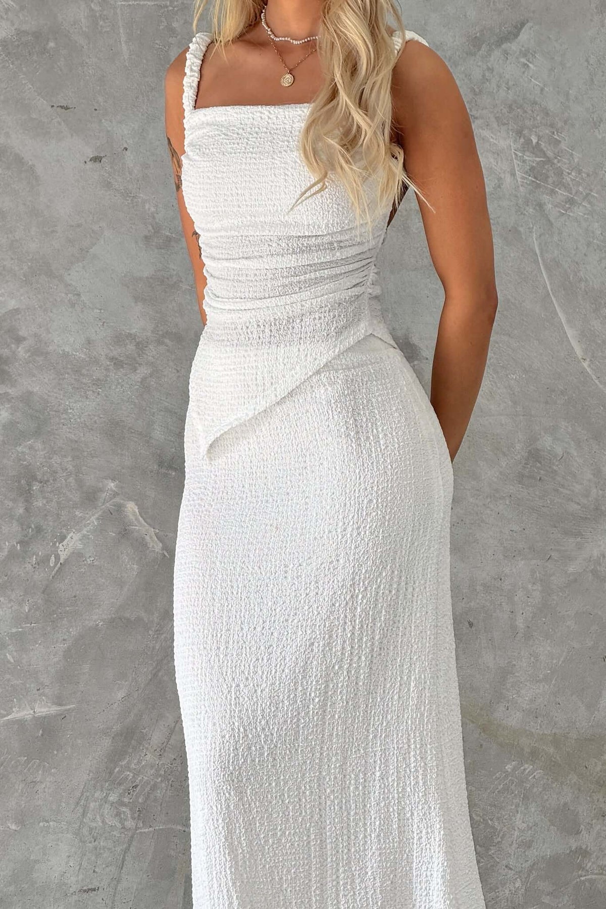 Women’s white maxi dress featuring ruched details and a fitted silhouette, perfect for elegant occasions.