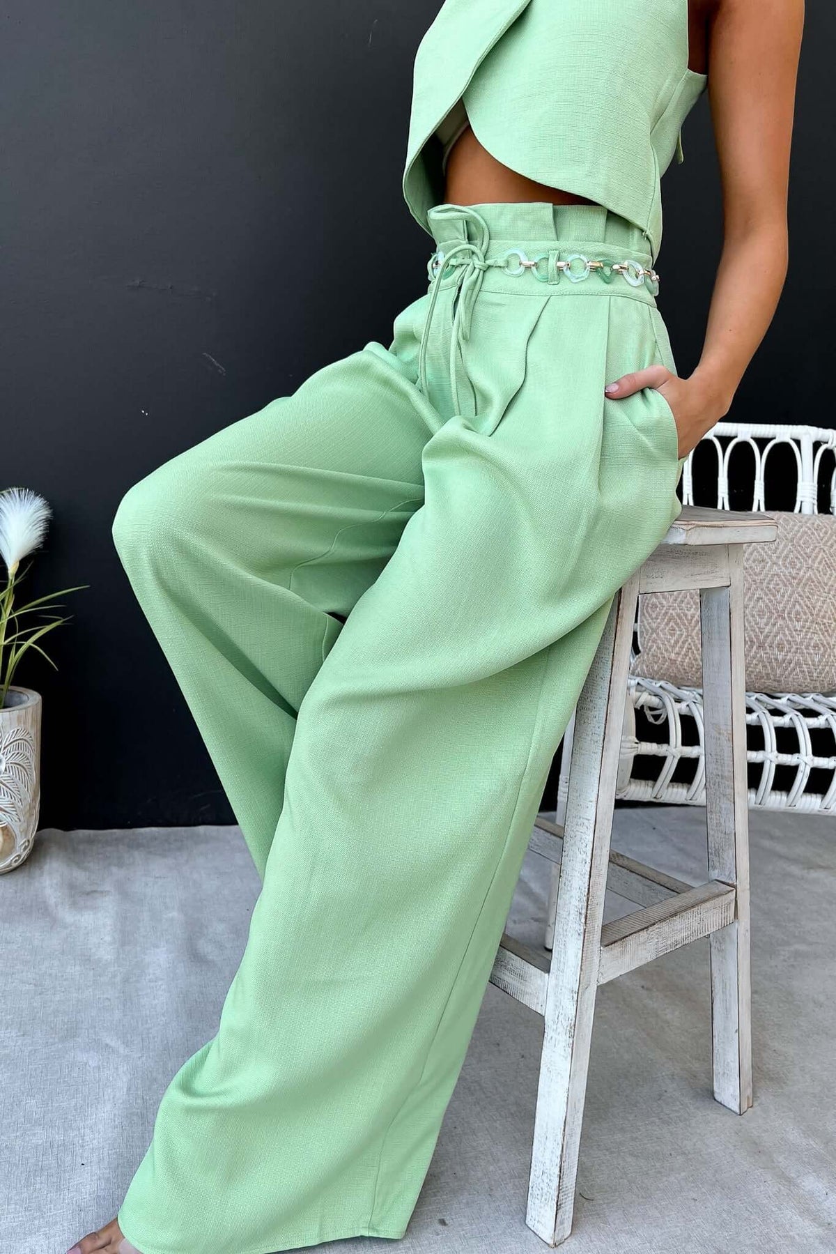 Light green Paytas Pants featuring a paperbag waist, removable belt, and pockets, styled with a matching top.
