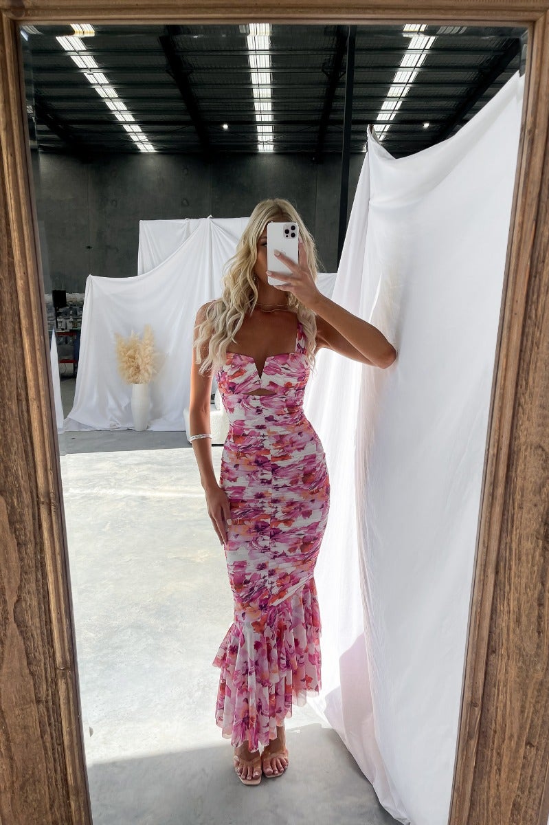 Model wearing Rosetta Maxi Dress, featuring floral print, fitted bodice, and ruffled hem, captured in a bright space.