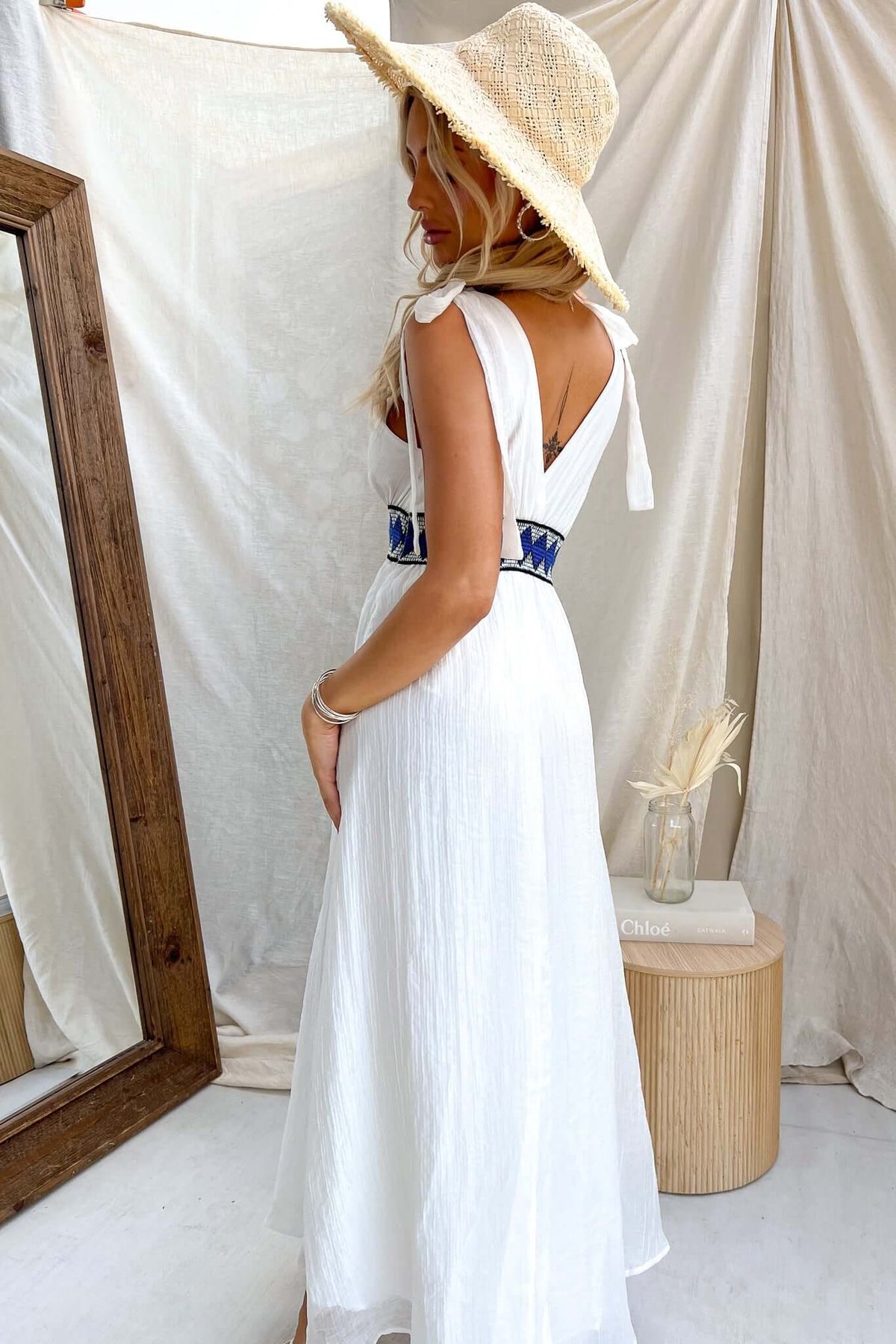 Model wearing Egret Maxi Dress with tie straps and elastic waistband, displayed in natural setting.