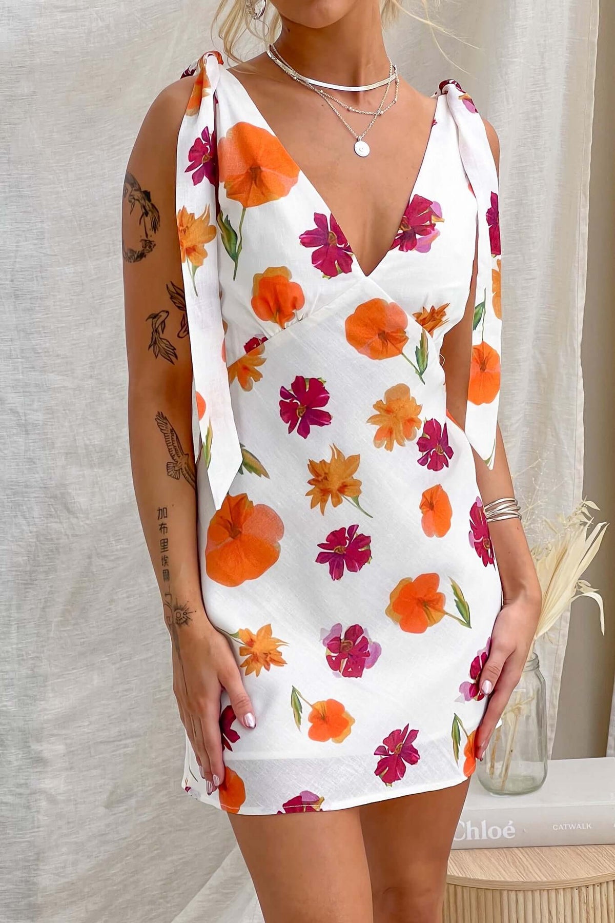 Floral print Kinsey Dress featuring adjustable tie straps and a light cotton feel, perfect for warm days.