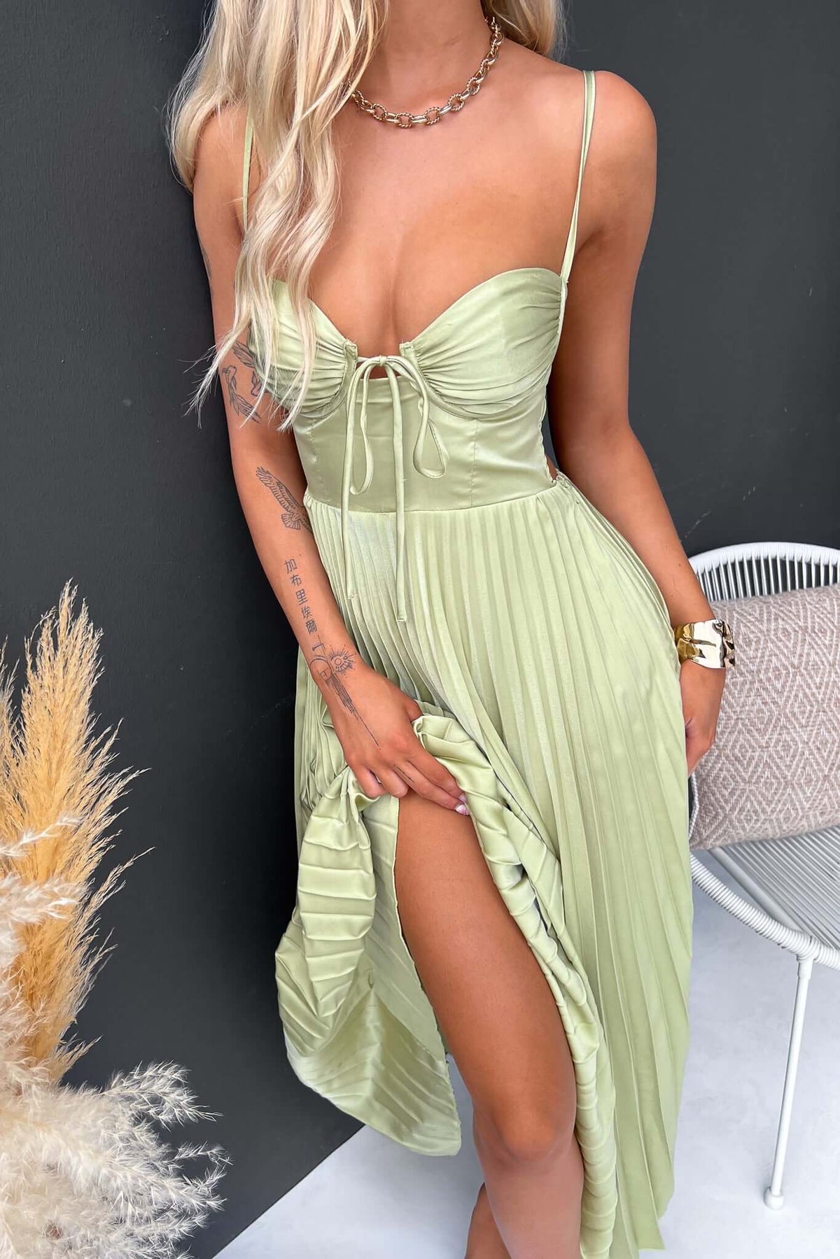 Model wearing a light green Danette maxi dress with adjustable straps and pleated design.