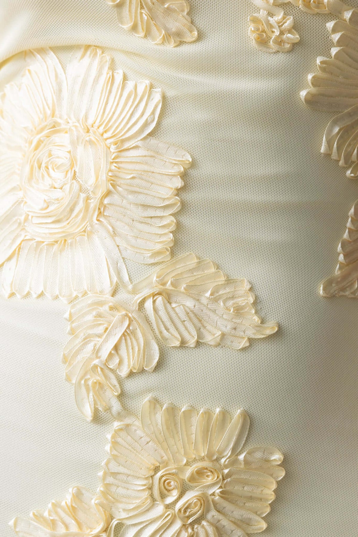 Close-up of embroidered floral design on a cream fabric, showcasing intricate detailing perfect for a maxi dress.
