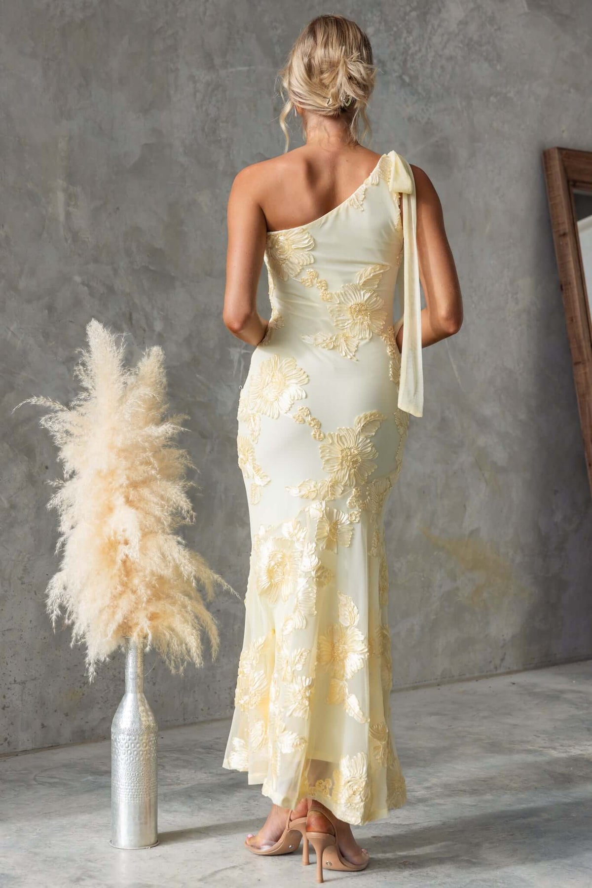 One-shoulder Inspire Maxi Dress in pale yellow with embroidered details, styled with a tie and elegant fit.