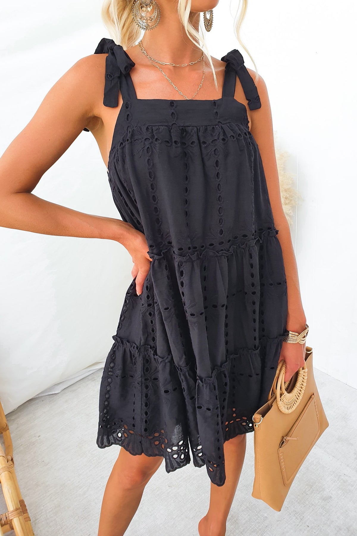 Model wearing Charlene Dress, a black Anglaise cotton dress with adjustable tie straps and lined design.