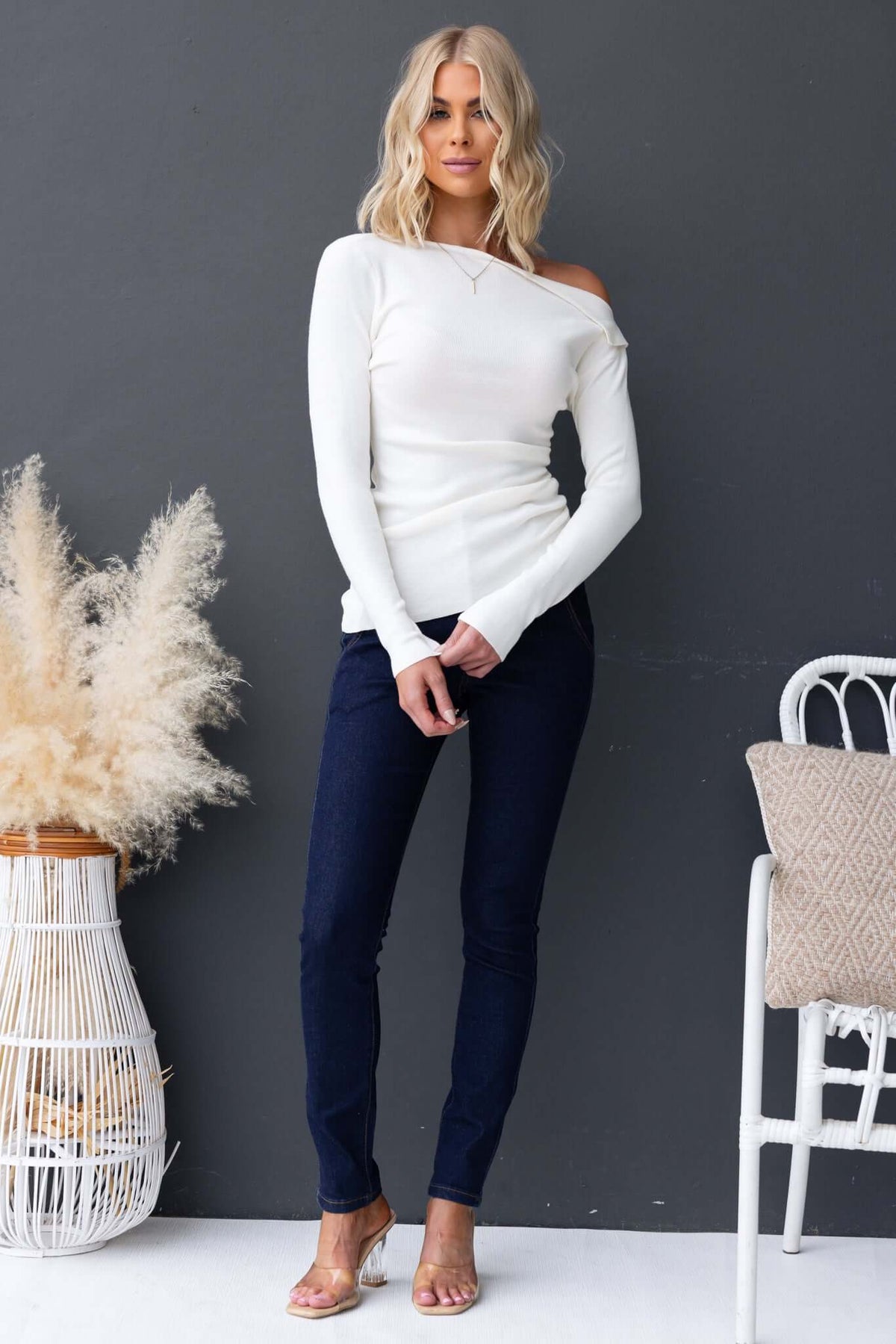 Model wearing Isla Top with asymmetric neckline and hem, styled with navy jeans and minimalistic accessories.