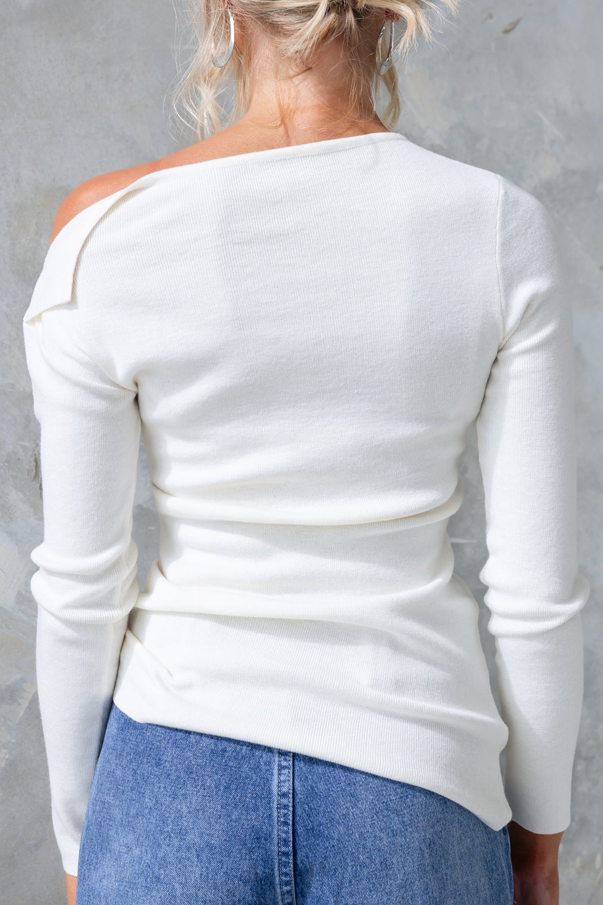 Back view of Isla Top featuring asymmetric neckline and hem in knit material, perfect for a stylish, casual look.