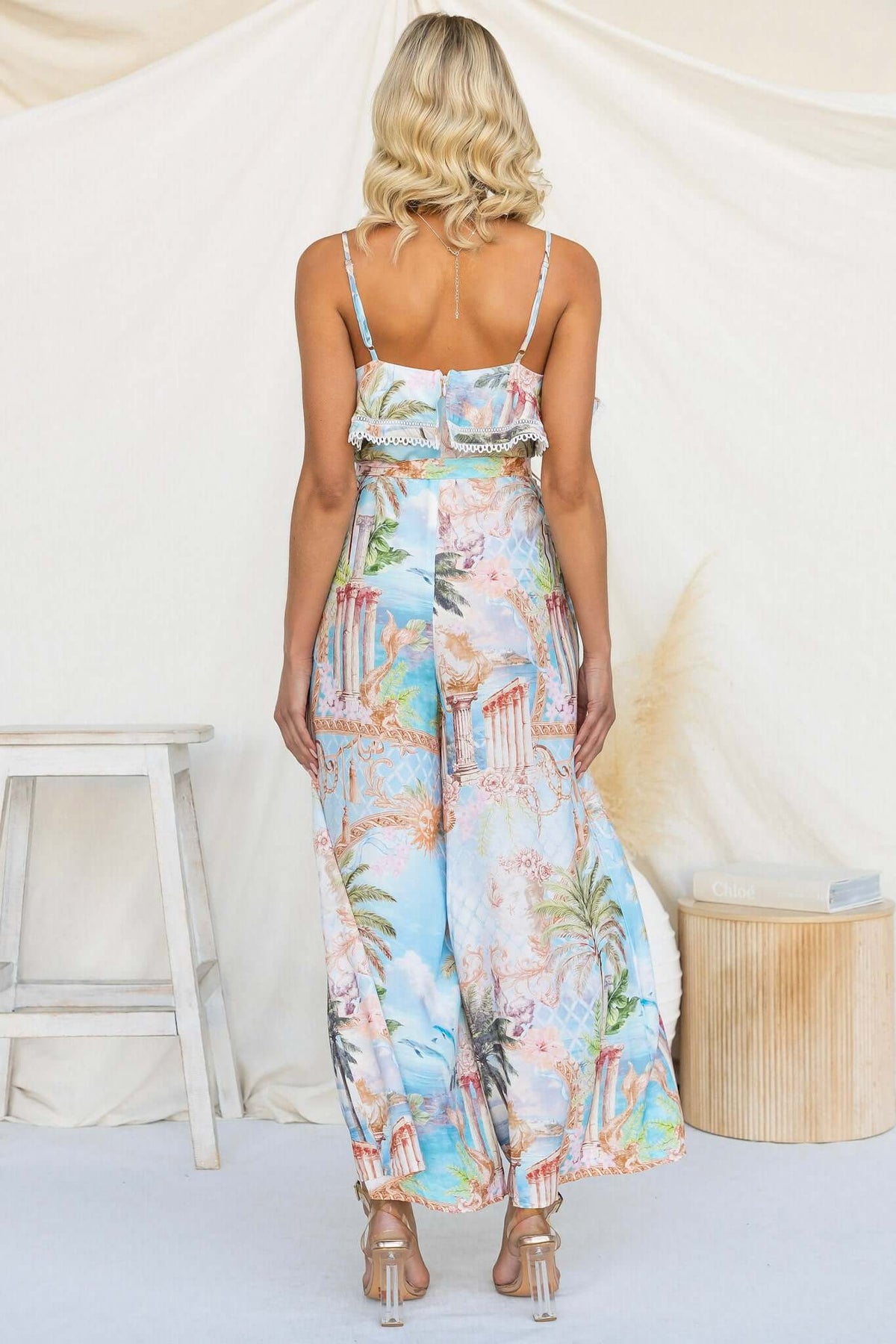 Back view of the Island Escape Jumpsuit featuring adjustable straps and a colorful tropical print.