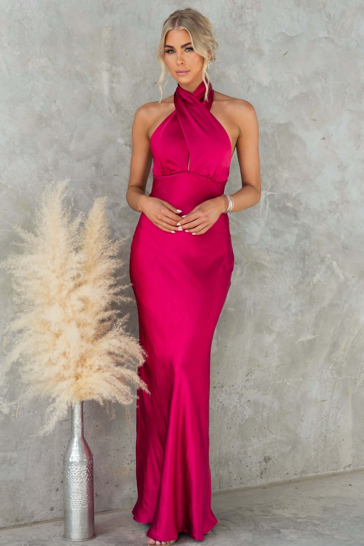 Iyanna Maxi Dress in vibrant magenta with halter neckline and adjustable tie, showcasing elegant satin fabric.