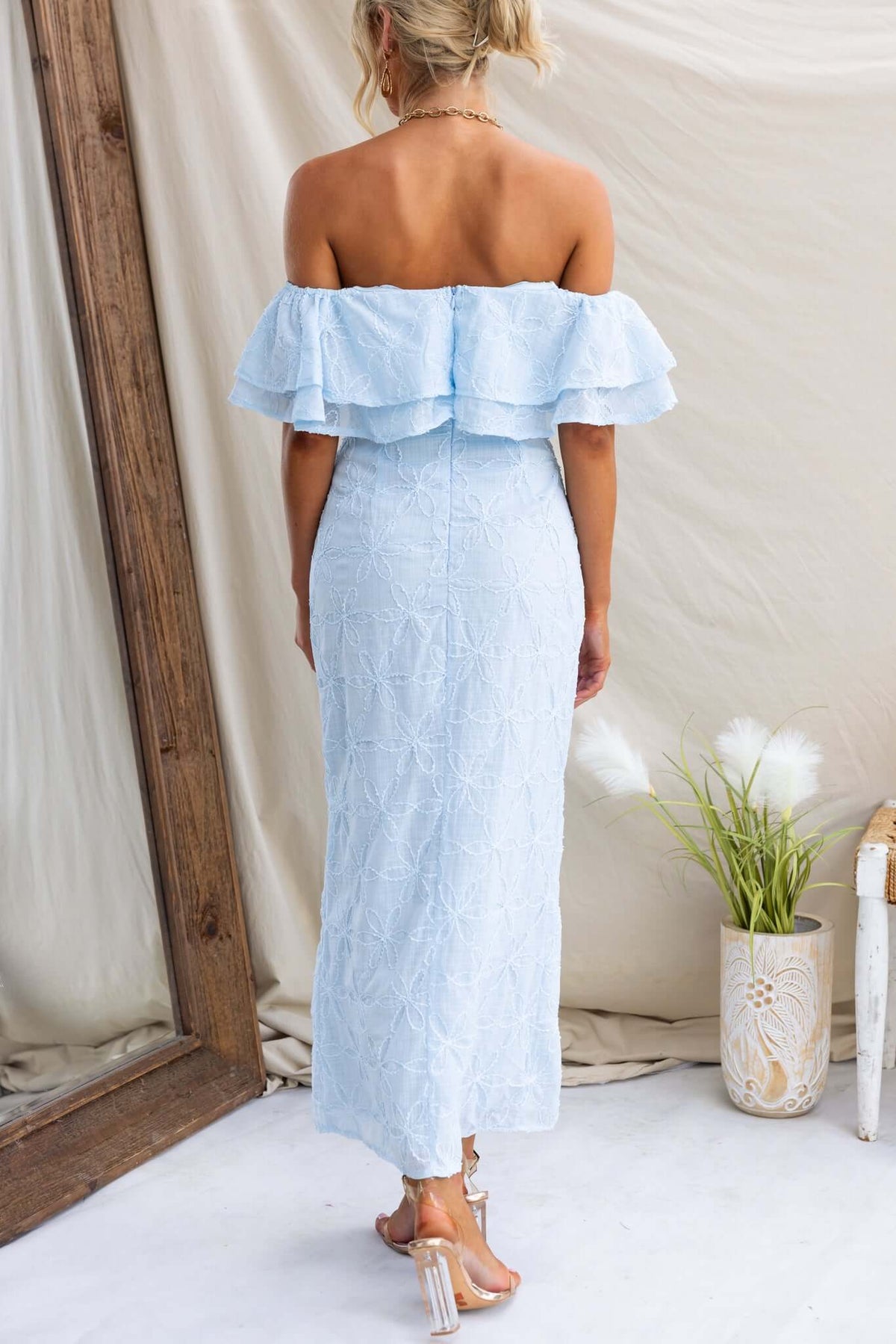 Back view of the Jaqcues Maxi Dress in light blue, featuring off-the-shoulder ruffles and textured material.