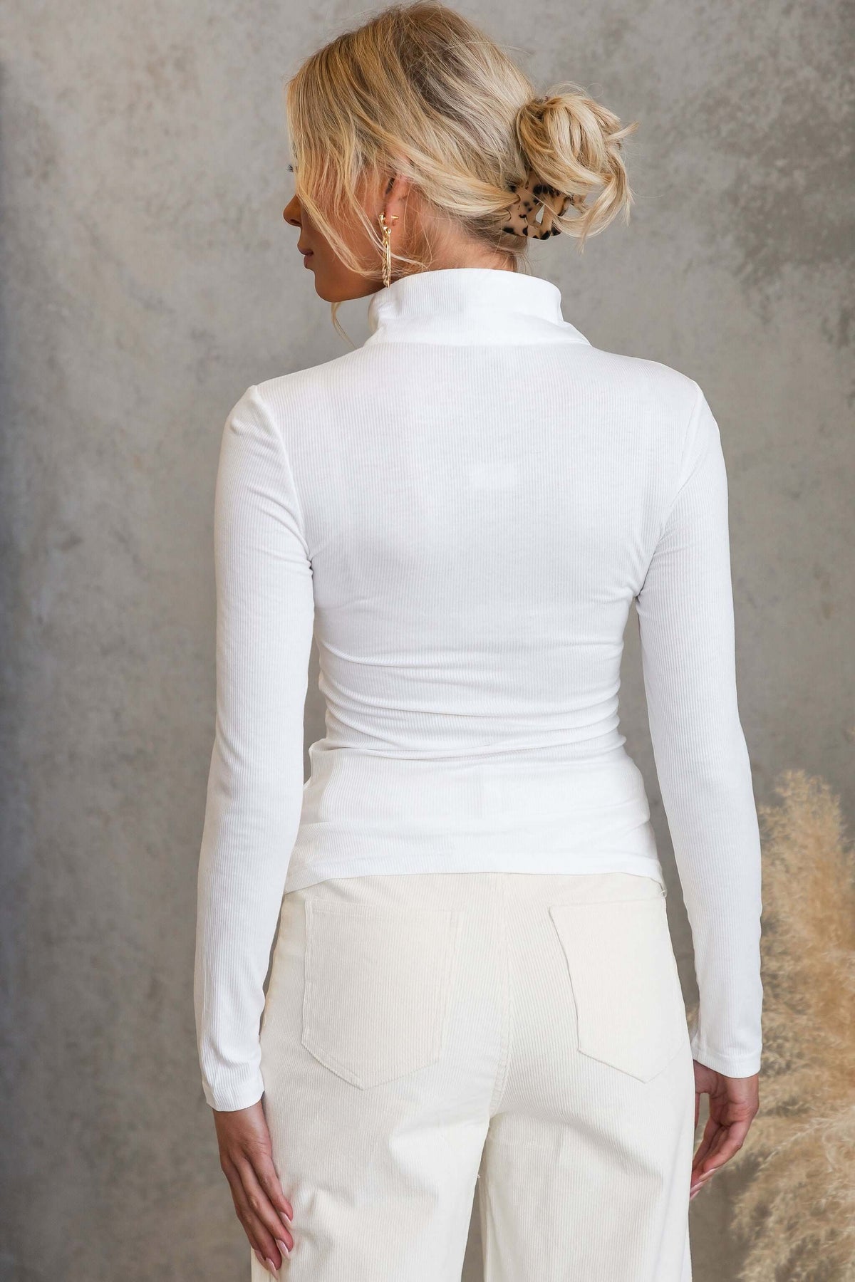 Back view of a woman wearing the Josia Top, showcasing its round neckline and fitted design.