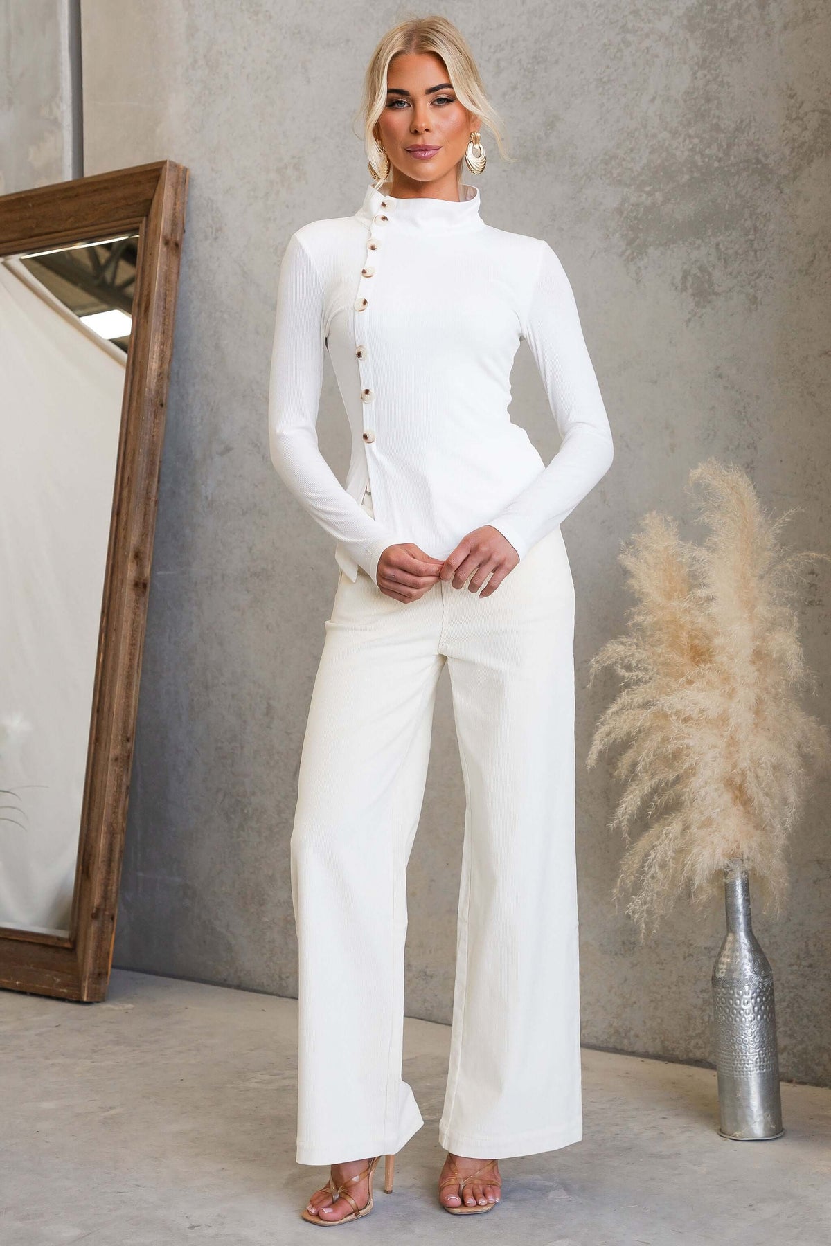 Josia Top featuring a round neckline and faux button-up front, styled with wide-leg pants.