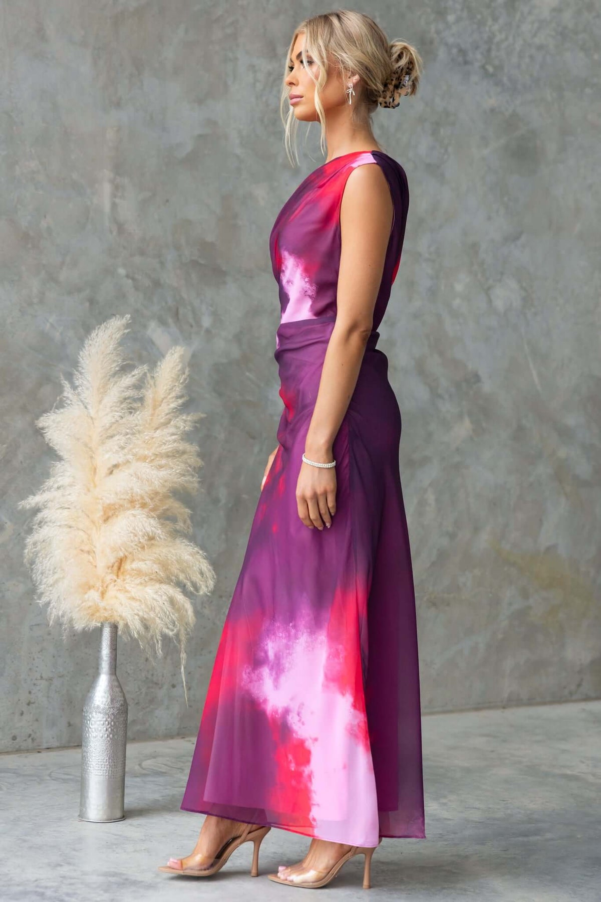 Elegant Jules Maxi Dress featuring asymmetric neckline and side ruching, styled in vibrant purple and pink hues.